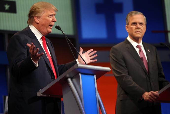 Republican presidential candidate Donald Trump speaks as  Jeb Bush watches during the FOX News Channel  Republican presidential debate at the Quicken Loans Arena Thursday, Aug. 6, 2015, in Cleveland. Republicans are steeling themselves for a long period of deep uncertainty following a raucous first debate of the 2016 campaign for president, with no signs this past weeks Fox News face-off will winnow their wide-open field of White House hopefuls anytime soon.   (AP Photo/Andrew Harnik)