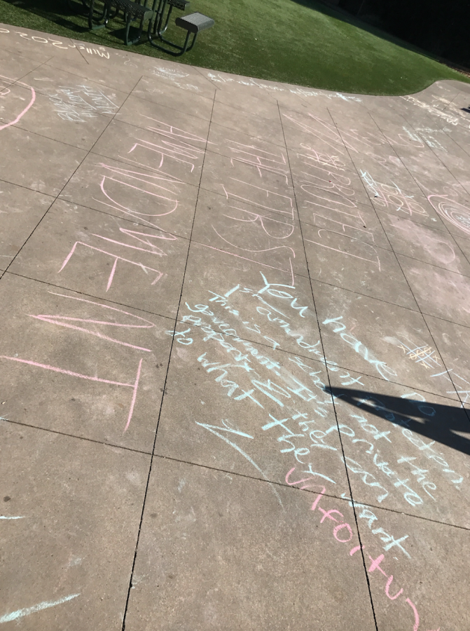Students write controversial messages during Valentines Day chalk activity