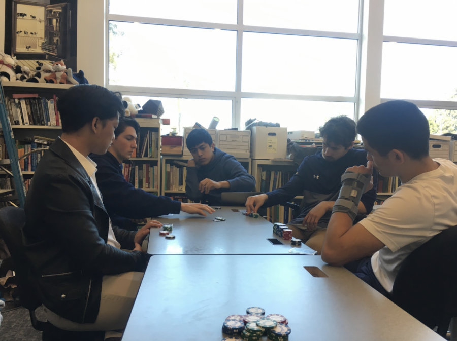 A group of seniors gather in the Neighborhood, a classroom in the back of the library, to play poker during lunch. Staff Photo: Shefali Sahai.