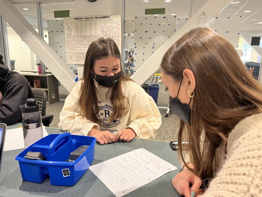 Seniors Michaela Chou and Charlie Herrin look over an underclassmens goal sheet in the Learning Center. TAs often go to the Learning Center to help students with writing assignments. Staff photo: Riley Huddleston.
