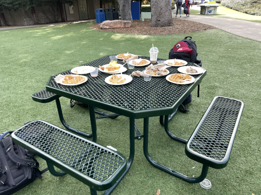 A trash-laden table is abandoned after lunch before the holiday assembly. Trash is often left behind by students on the quad. Staff photo: Andrea Li