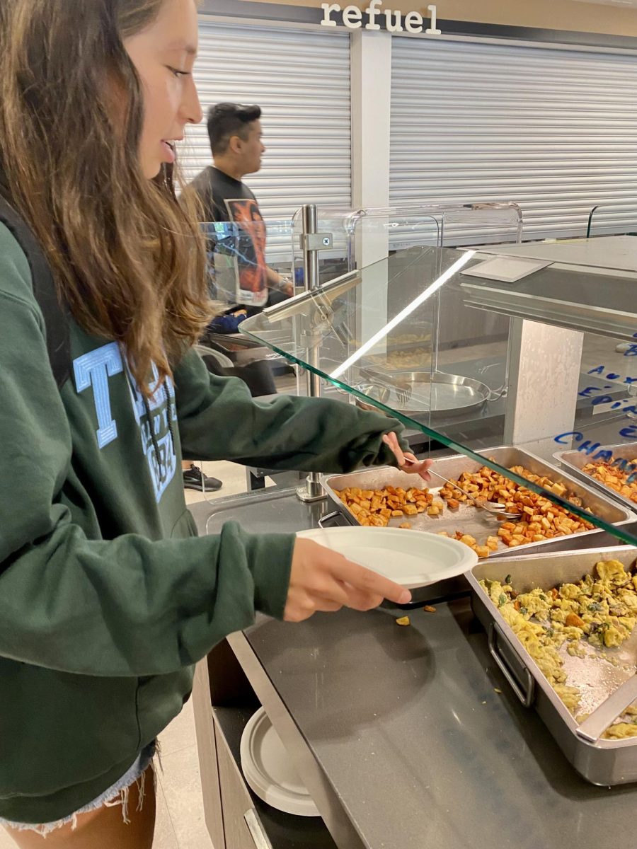 Junior Sofia Aguilar served herself potatoes in the cafeteria on Friday, Aug. 23.