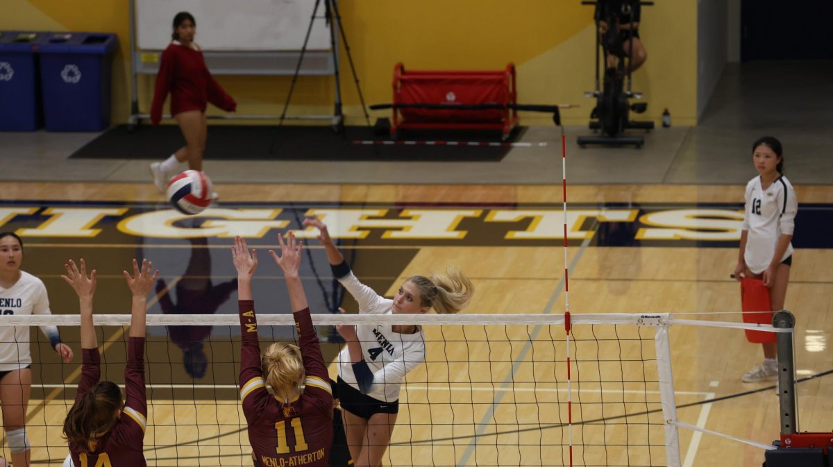 Senior Bryn Dombkowski spikes the ball past M-A blockers.