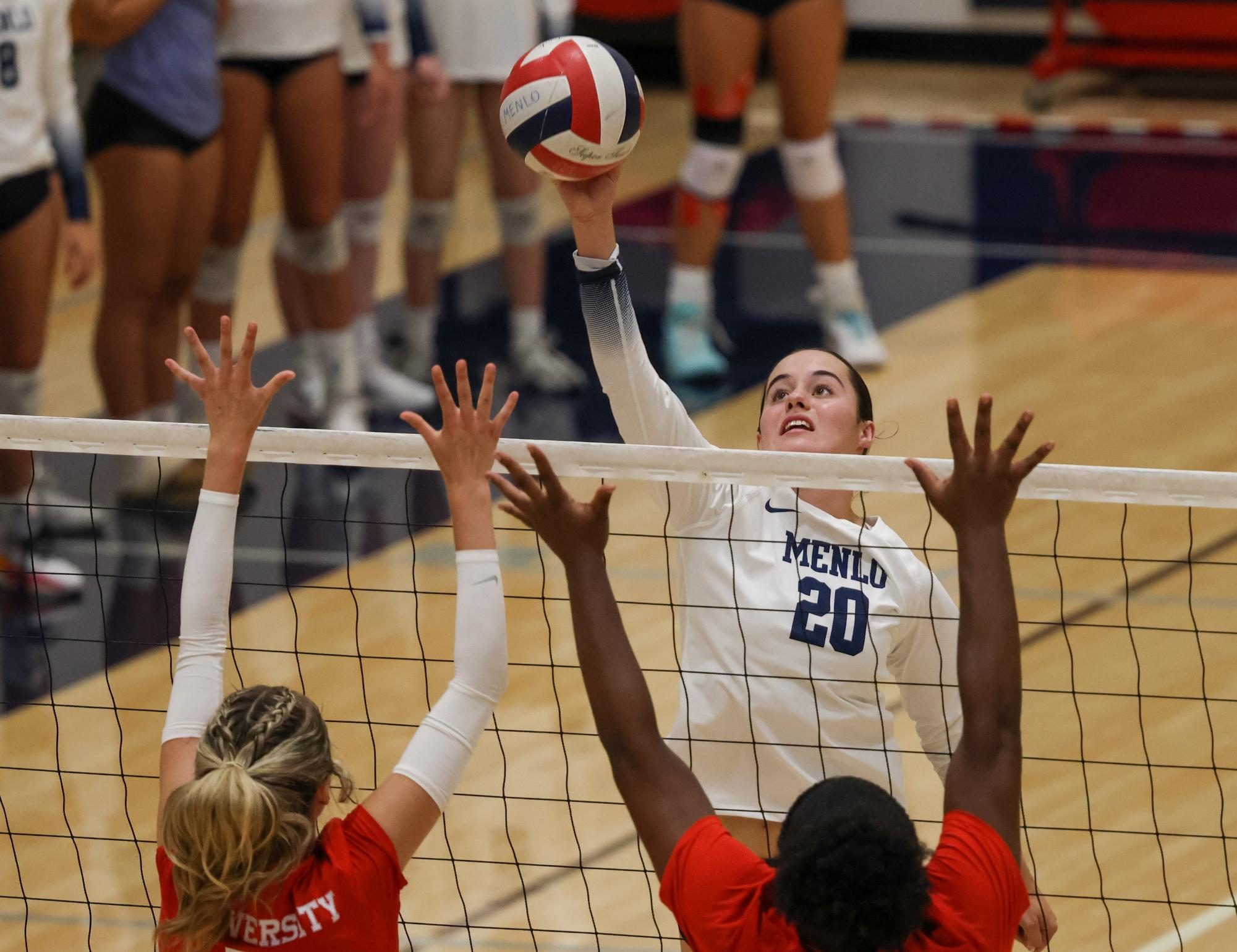 Senior Lauren Mrva tips the ball over Aragon’s blockers.