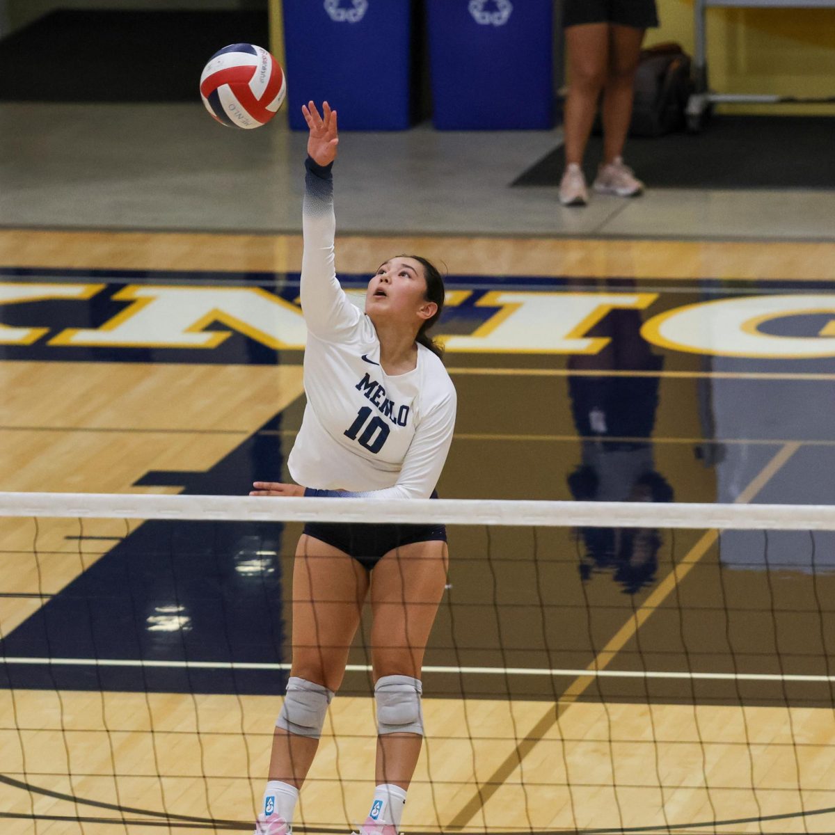 Freshman Alex Fair spikes the ball over the net.