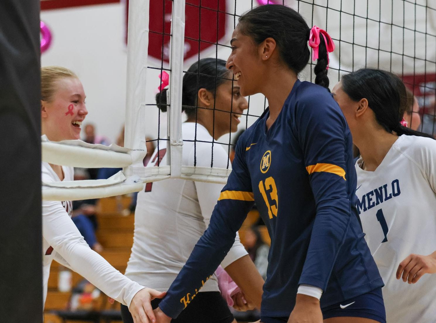 Senior Lily Kautai high-fives a SHP player’s hand before the match