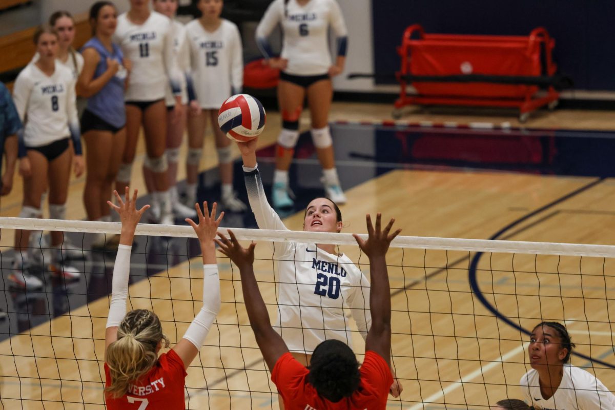 Senior Lauren Mrva tips the ball over
University High School’s blockers in a game on Sept. 4.