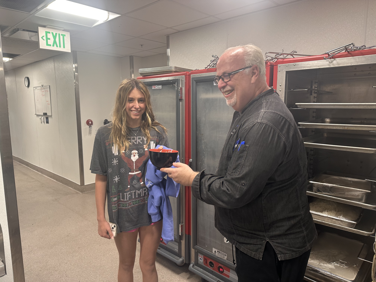 Executive Chef Ken Sligar serves food to sophomore Daphne Ryerson.