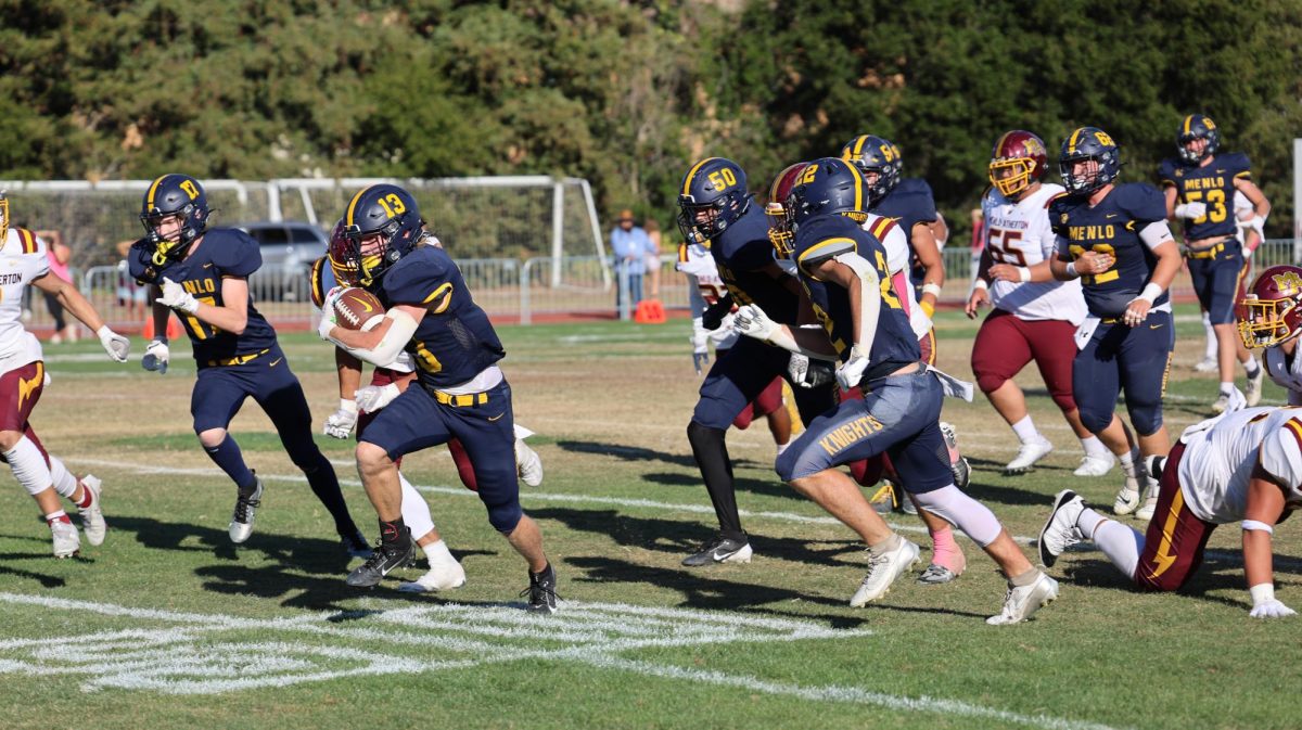 Junior wide receiver Trevor Van Der Pyl (#13) bounces off tacklers and escapes on a huge gain for the Knights in the second quarter.