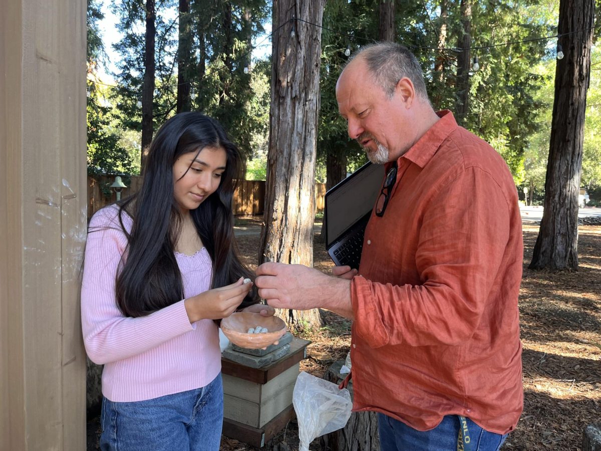 Science teacher David Spence speaks to senior Mari Martinez-Luna about the beads she made for a project in Experimental Archaeology. 