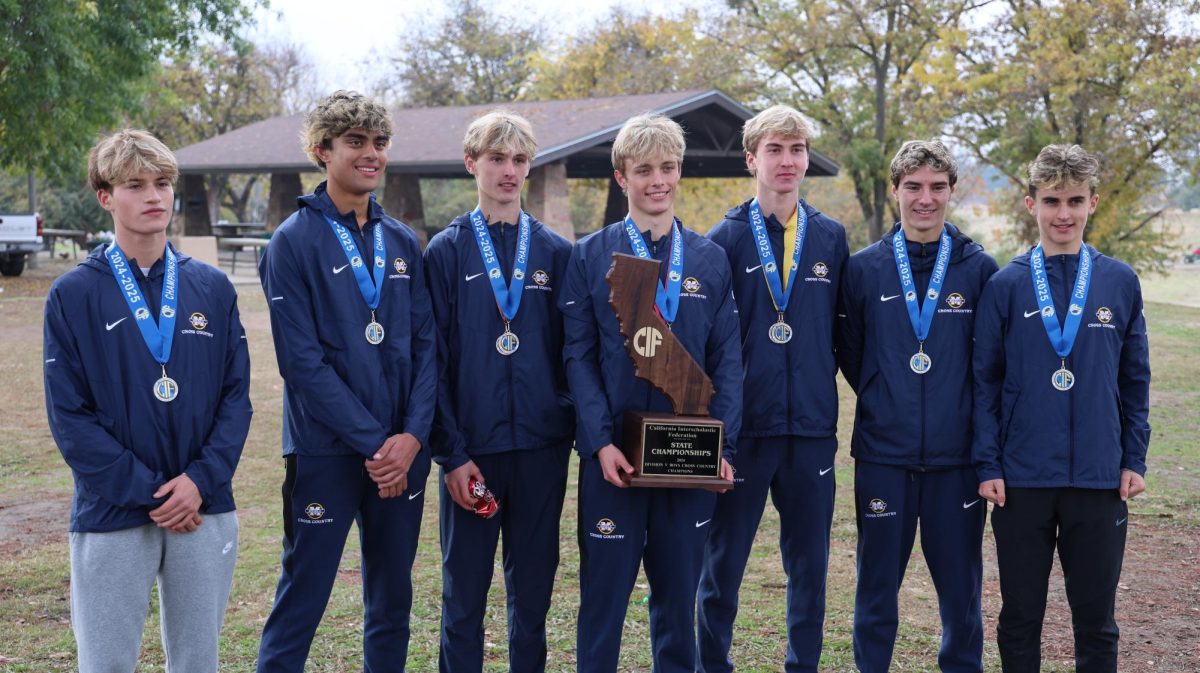 Sophomore Jonah Block, junior Amay Srinivasan, sophomore Henry Hauser, senior Landon Pretre, senior Will Hauser, senior Jared Saal and freshman Oliver Olbekson pose after placing first in the CIF Cross Country State Division V Championship. Photo courtesy of Miles Bennett-Smith.