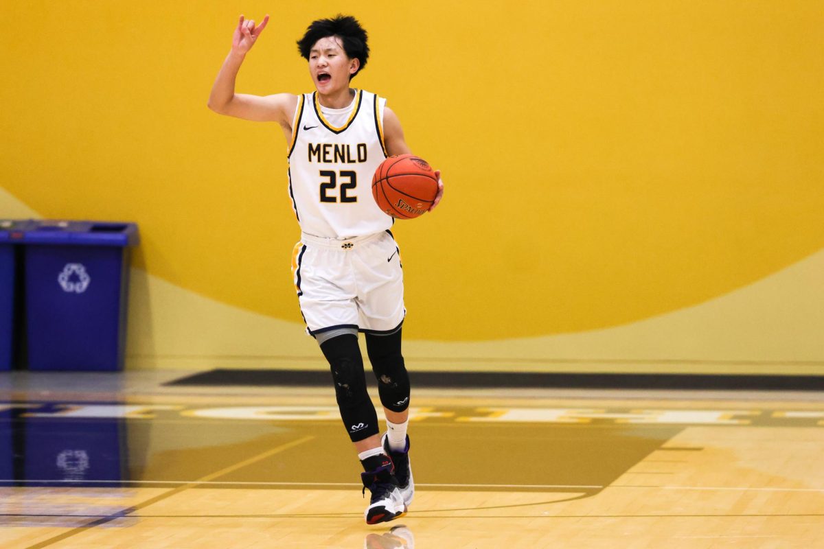 Junior Ethan Zhao calls out a play while dribbling up the court.