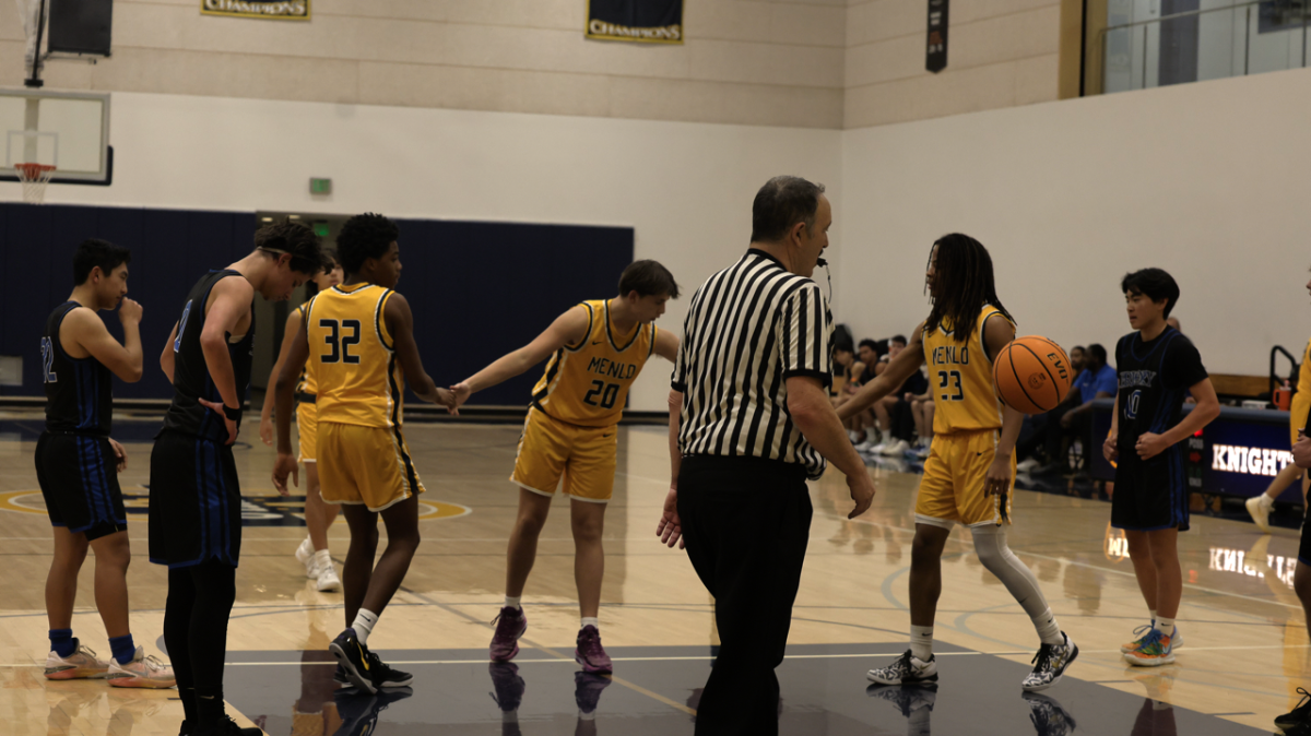 Sophomore William Lenihan (20) receives high fives from his teammates, sophomore Kai Mawakana (23) and freshman Tres Onyejekwe (32), after earning a free throw during a game against Priory on Feb. 7.