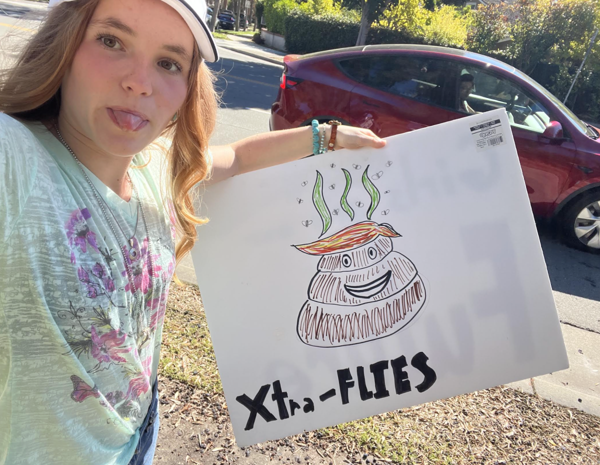 Senior Claire Barnett holds up a poster she made for the No Kings Protest. 