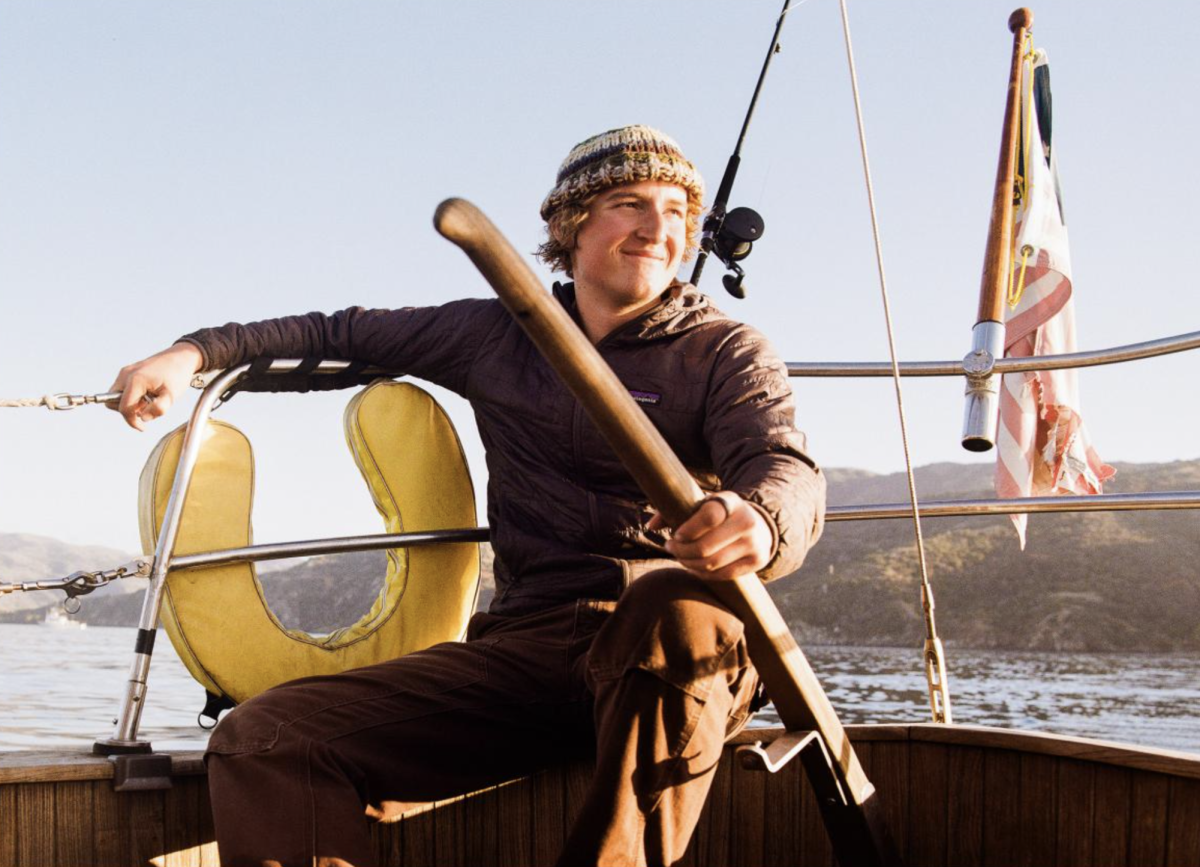 Tyler Mitic holds the tiller of his sail boat nearby the North End of Catalina Island