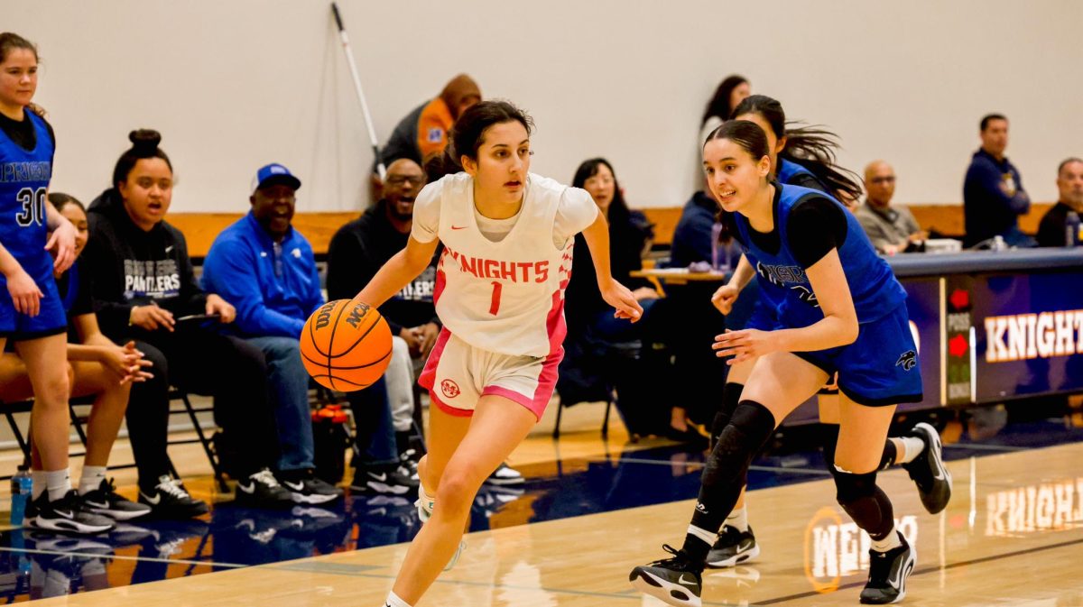 Junior Sophia Longinidis dribbles the ball past a defender.
