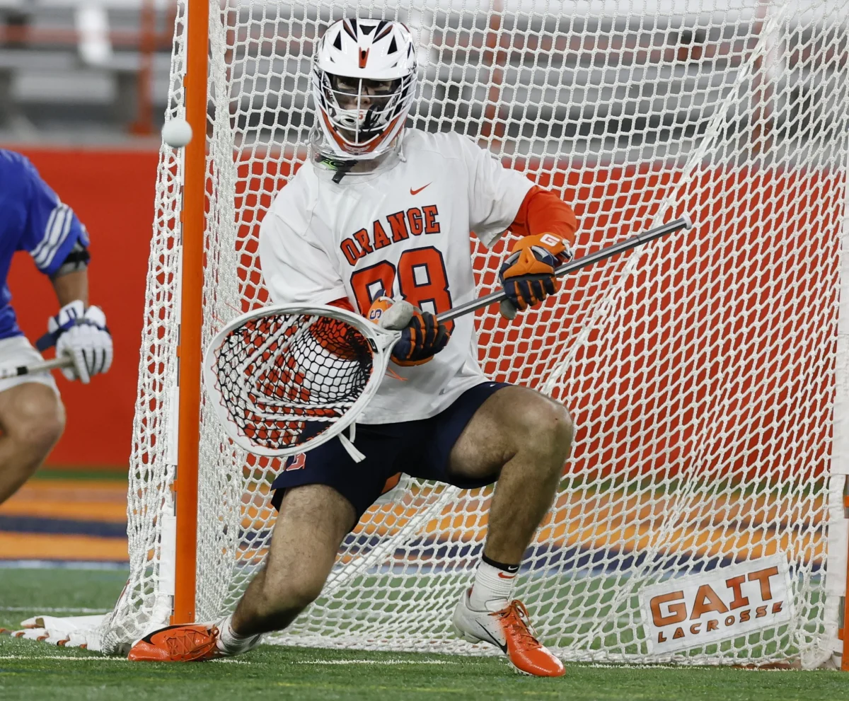Will Mark defends a shot while playing for Syracuse. Mark was recently hired as Menlo’s boys  lacrosse head coach. Photo courtesy of ADVNC Lacrosse